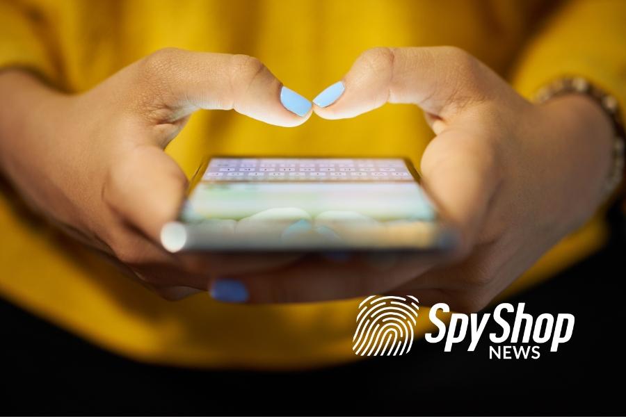 Zbliżenie na dłonie kobiety z pomalowanymi paznokciami, w których mieści się telefon z włączonym komunikatorem typu WhatsApp
