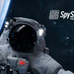 Kosmonauta w skafandrze unosi się w przestrzeni kosmicznej. W tle widać Ziemię.