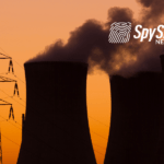 Kominy elektrowni jądrowej i słup energetyczny, a w tle zachód słońca