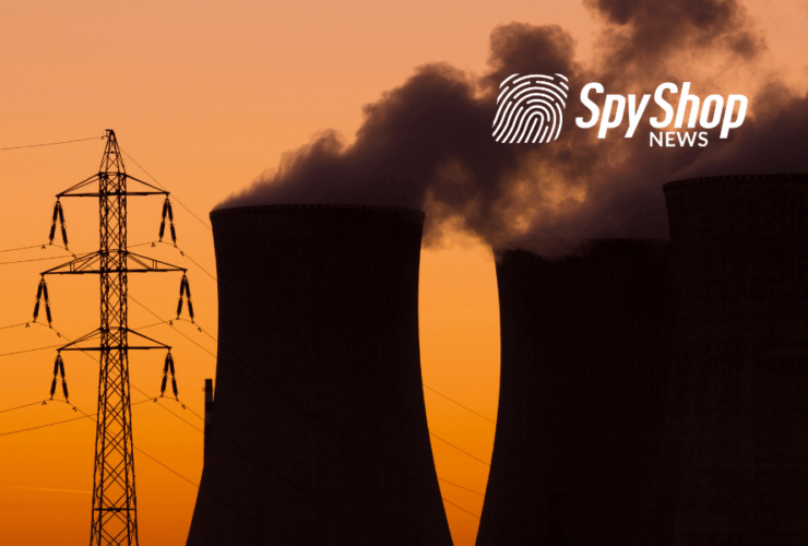 Kominy elektrowni jądrowej i słup energetyczny, a w tle zachód słońca