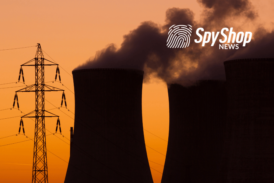Kominy elektrowni jądrowej i słup energetyczny, a w tle zachód słońca