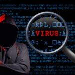 Na fotografii został przedstawiony haker oraz słowo wyróżnione na czerwono VIRUS