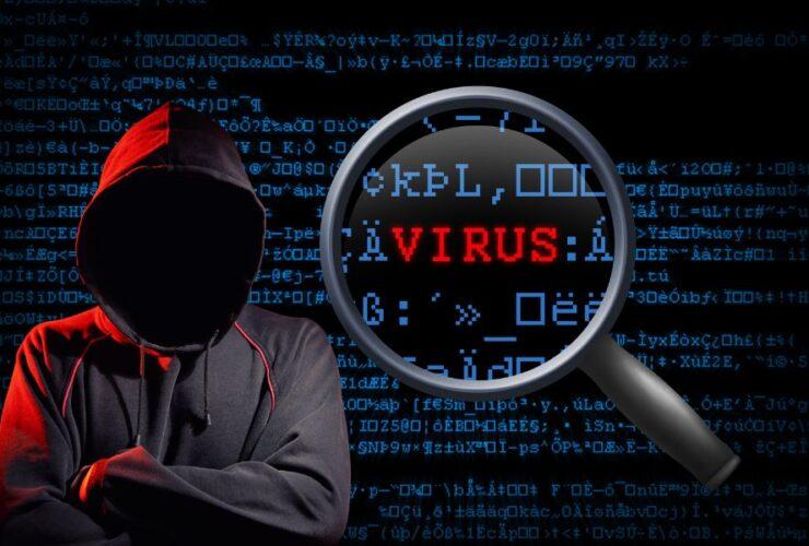 Na fotografii został przedstawiony haker oraz słowo wyróżnione na czerwono VIRUS